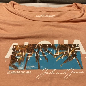 Rosa orange T-shirt  - Bra kvalitet, i väldigt bra skick. Knappt använd. Står Aloha på brösten, köpt från Jack & Jones