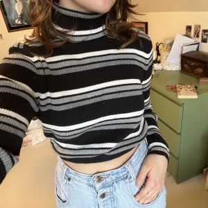 Croppad polotröja - Jättefin varm stickad randig polotröja från Beyond Retro. Den har ett gummiband längst ner som gör att den smiter åt och blir croppad.🧶🤎🖤