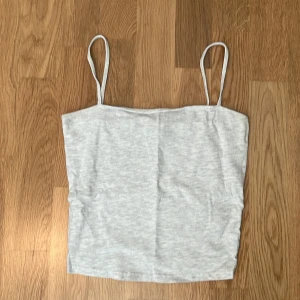 Tank top från H&M - Ljusgrått linne från hm med tunna straps. Den går ungefär till naveln, men det varierar beroende på bröststorlek. Jag kan bara komma ihåg att jag använt den en gång men MAX 2 gånger. Inga fläckar eller slitningar. Det 
