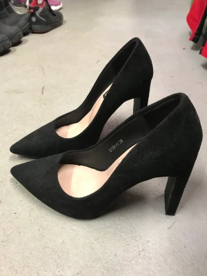 Svarta med hög klack  - Svarta snygga högklackade skor. Obetydligt använda. Storlek 38