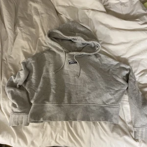 Adidas hoodie - En grå croppad hoodie i märket adidas. 