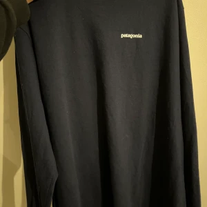 Patagonia tröja - Skön stor och fet patagonia tröja, mörklbå med tryck på ryggen. Den är storlek L men sitter som XL oversized. Använd 1 gång, säljer för att den är för stor. (Kan även frakta tröjan)!!