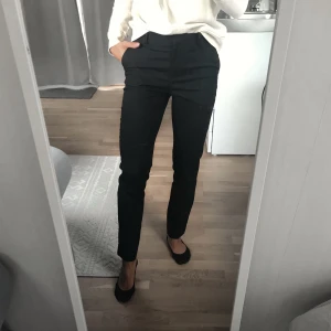 H&M - Kostymbyxa 34 - En klassisk, avsmalnande kostymbyxa i svart. Inköpspris 249kr, säljs för 100kr. En klassisk hellång modell med snäv passform och normalhög midja. 68% Polyester, 30% Viskos, 2% Elastan 