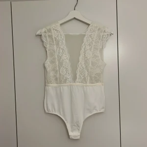 Vit spetsbody  - Säljer denna vita spetsbodyn från Vero Moda i storlek M. Aldrig använd med prislapp kvar. 