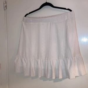 Vit kjol Storlek XL - Vit kjol med volanger. Helt oanvänd med prislappen kvar.