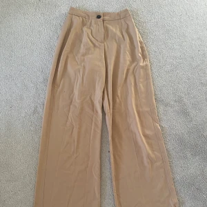 Kostymbyxor - Beiga kostymbyxor med as snygg passform! Liten ficka baktill, vida ben och tajt vid midja/rumpa! ✨ Säljer för har för många kostymbyxor! Kan både fraktas inom Sverige och mötas upp i luleå🤍