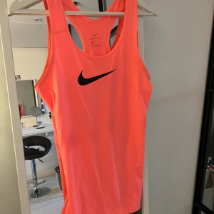 Nike träningslinne  - Superfint träningslinne från Nike i korallfärg. Oanvänd och i bra skick 