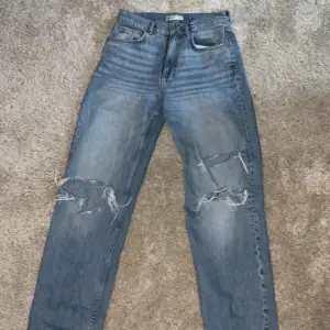 Premium Denim jeans i storlek 36 med hål vid knäna.