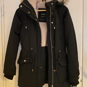 Black parka with soft fake fur lining and hood. Excellent condition. 