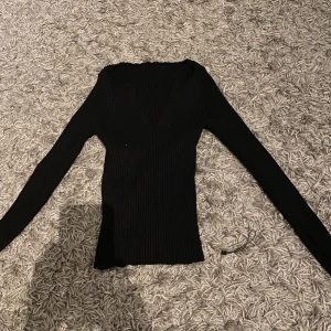 Svart tröja - Super fin svarttröja med v ringning. Super skönt material som är stretchigt och bekvämt. Ger kroppen en väldigt fin form
