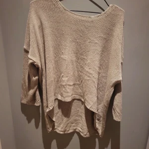 Stickad tröja - Stickad tröja från lager 157 i storlek M. Har används många gånger och några trådar Har dragits ut av katter. Den är längre på baksidan än framsidan. 