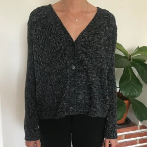 Stickad kofta/cardigan i ull från Sand - Jättefin stickad tröja från Sand med knappar fram. Färgen är mörkgrå och lite blågrå-melerad. Står ingen storlek men skulle tippa kanske M-L i dam, lite boxig och oversize i formen. 100% Lammull. Kan mötas i Malmö eller Lund eller skicka! 