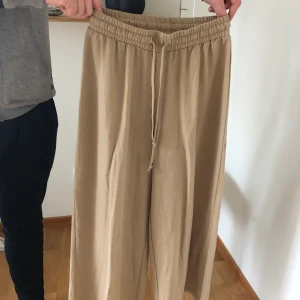 Beigea linnebyxor  - Ankellånga. Sparsamt använda! 