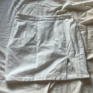 Vit kjol med slits - En vit kjol i nyskick med en slits. Klan behövs styckas