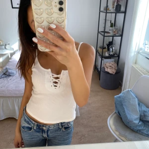 Vitt linne med snörning - Vitt linne med snörning som man kan justera. I fint skick. Kan mötas upp eller frakta.