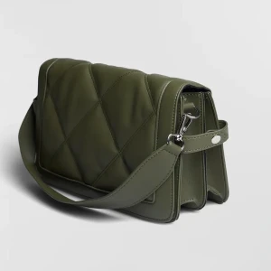 Grön väska ginatricot  - Hej! Säljer en grön väska från Ginatricot. Man kan ha den över axeln och crosbody, det medföljer ett långt band. Stl är 17 x 30 cm. Nypris 379kr. Använd fåtal gånger, som ny🥰