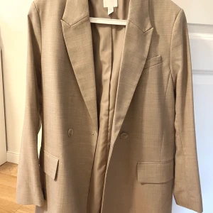 Oanvänd kavaj från H&M, storlek XS - Oanvänd kavaj från H&M i storlek XS. Fint material som känns väldigt lyxigt (se bild nummer 2). Frakt tillkommer! 🤍