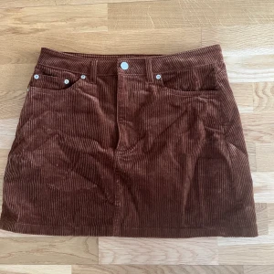 H&M Miniskirt - Säljer min favvokjol pga har blivit för liten :( Superfin miniskirt i bodycon passform i kopparbrunt manchestertyg (slide för färg). Mycket fint skick - använd endast en gång. Storlek 40, men upplever den som kort. Köparen står för frakt