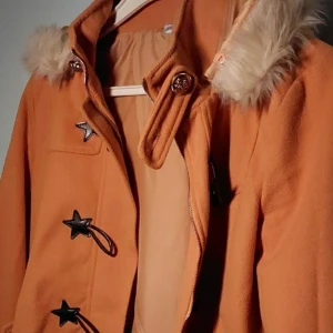 Kappa - Det är en orange brun kappa med söta öron och coola knappar vid nacken och armarna. Pris kan diskuteras:)