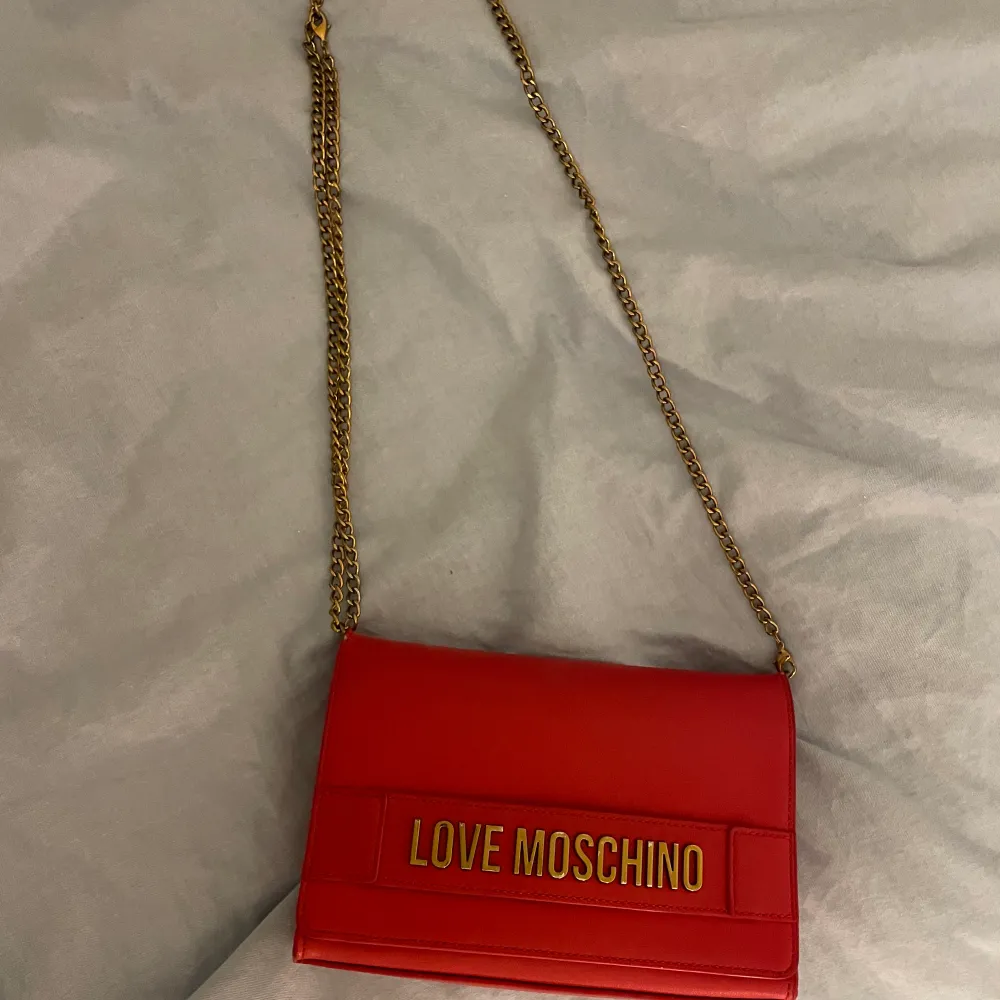 Röd Moschino väska med justerbar guldkedja (orginalpris 1100kr)❤️. Väskor.