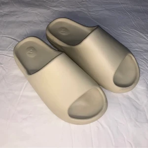 addidas Yezzy slides bone strorlek 44 - Vanligt vis trånga så passar 43 också Köpte de på Plick men har inte använt och de passa inte helt. 