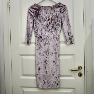 Silver sammetsklänning (xs/s) - Färgen är silver och skiftar lite åt lila hållet. Tight modell och sitter väldigt fint. Perfekt till utekvällar eller lite finare tillställningar. Storlek xs/s. Materialet är   stretchig. Ryggen har en urringning. Fraktsätt kan diskuteras. 