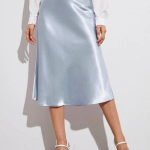 Ljusblå silkeskjol storlek S - Fin ljusblå silkeskjol som införskaffades för ca 7 månader sedan. Har endast används 1 gång och är i bra skick. Inköpspris: 249kr 