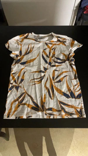 Vit t-shirt med löv mönster - Vit t-shirt från dressman med löv mönster 