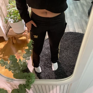 Adidasbyxor  - Adidasbyxor med guld detaljer. Storlek m, men mer som xs/s.
