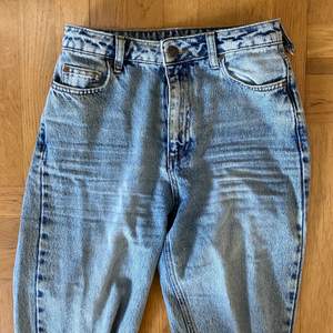 Högmidjade jeans i en ljusare tvätt, rak form och sitter perfekt på. En ögla är sönder så det är ett mindre hål i midjan. 