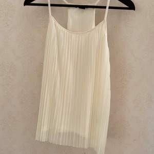 Vitt linne i plisserat tyg  - Vitt linne i plisserat tyg från hm. Aldrig använd. 