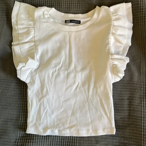 Vit volangtopp från zara - En vit volangtopp från zara som är perfekt till sommaren. Aldrig använd. Köpare står för frakt ✨