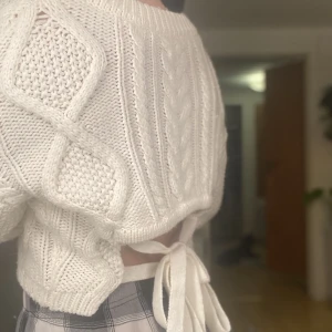 Kabelstickad tröja  - Vit Kabelstickad tröja med snörning på ryggen  från Nakd. Använd få tal gånger därav i väldigt bra skick.🤍