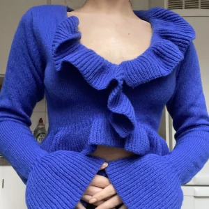 Stickad tröja med volanger - Blå stickad tröja med volanger i storlek XS. Nyskick