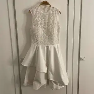 En vit klänning med inbyggd bh och spetsmönster upptill. Blixtlås baktill. Den är i nyskick, har använt den en gång och säljer nu för att den är för liten. Köpte för 599, Storlek xs💗