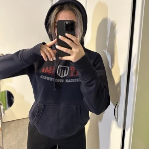 Gant hoodie - Blå gant hoodie. Bra skick förutom att 2 av 3 stjärnor ramlat av vid märket därav biligare priset! 