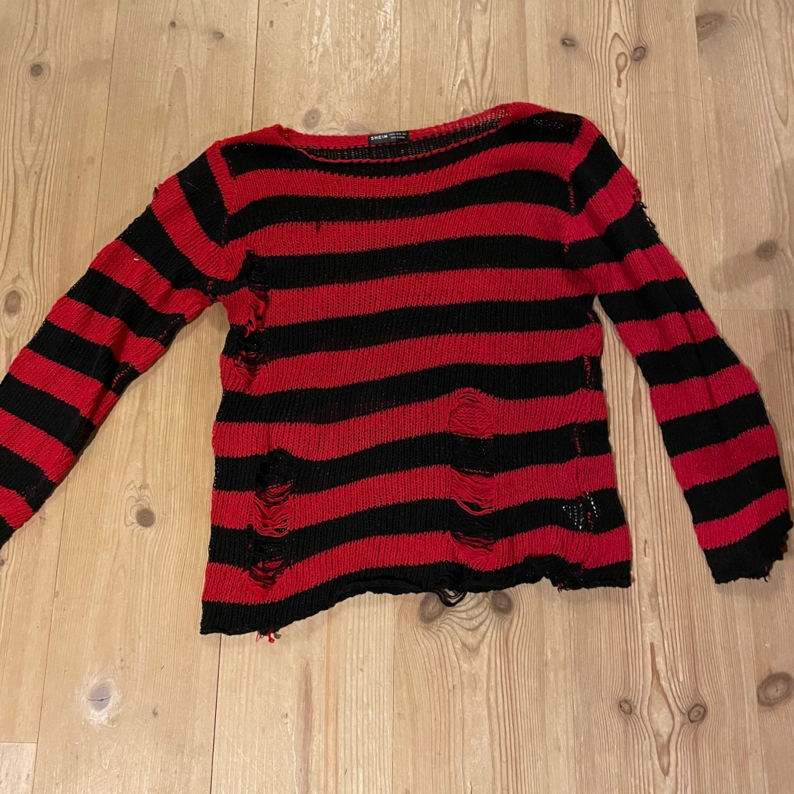 Svart/röd randig stickad tröja.