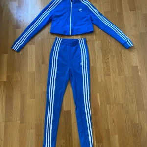 Adidas set - Nästan oanvänt set från adidas med croppad topp. Byxorna går att spänna in i midjan och både topp och byxor är i storlek 34. 