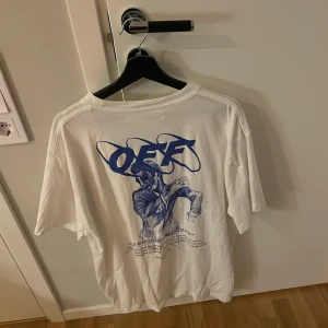 OFF WHITE T-SHIRT I STORLEK M - Riktigt snygg OFF-WHITE t-shirt i färgen vit och blått tryck på ryggen.  Storlek M men passar även L!  Väldigt Sällsynt t-shirt och du får med tags som tillhör t-shirten. Nypris 4400 Säljer för 750kr 