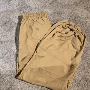 Parachute pants/cargo pants - Parachute pants från Uniqlo x JW anderson i beige. Aldrig använda! nypris 700