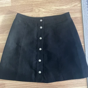 Svart kjol med knappar  - Svart kjol med knappar, köpt på HM, storlek 38  Köpare står för frakt