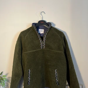 Butter Goods Glacier Sherpa 1/4 Zip up - En jättesnygg och bekväm zip up tröja från märket butter goods. Tröjan är otroligt bekväm och har en väldigt snygg mörkgrön färg. Jag har endast använt plagget två gånger, så nu har den bara hängt i garderoben på senaste. Skick 10/10