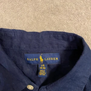 Polo RL skjorta - Säljer denna sjukt snygga mörkblåa skjorta från Ralph lauren. Den är bara använd en gång då den var för liten. Köpt för runt 1000kr skulle jag tro på kidsbrandstore.
