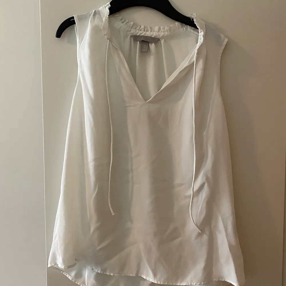 En söt vit blus från H&M som är köpt förra sommaren men inte kommit till användning då den varit för tajt. . Blusar.