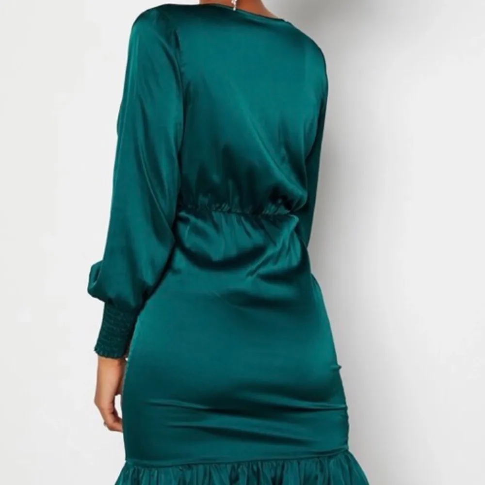 Grön satin klänning med volang nertill, V-ringad. Klänningar.