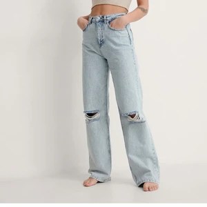 Helt nya oanvända jeans från NA-KD - Ett par ljus blåa jeans från NA-KD som aldrig är använda. Jag säljer dem då de är för små för mig och glömde lämna tillbaka dem. Jeansen är i storlek 36 och jag säljer dem för 450kr då original priset är 549kr. 