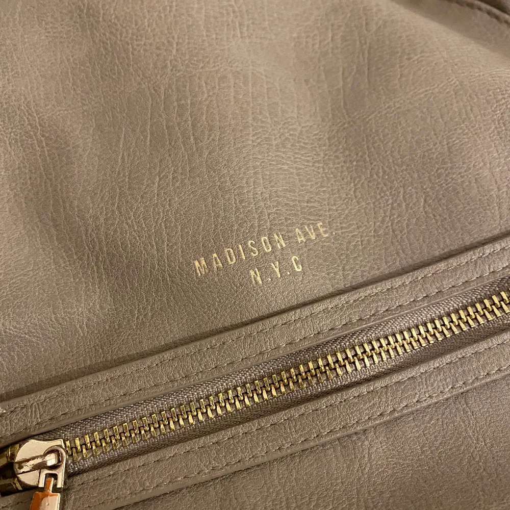 Säljer denhär gråa ryggsäcken från H&M. Väl använd men inga skador! Guldiga detaljer. . Väskor.