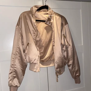 Jacka strl S - Tunn shiny jacka, beige med text på kragen, guldiga detaljer 