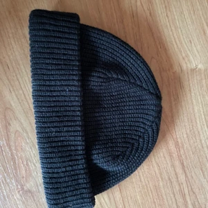 Svart låg mössa  - Sitter högt på huvudet. Aldrig använd. 