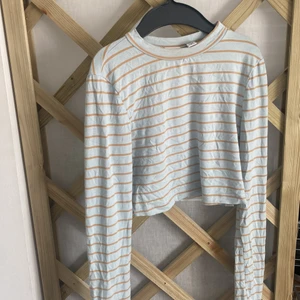 Magtröja - Säljer denna fina magtröja för att jag inte använder den längre. Den har guldiga streck och är ljusblå. Det är storlek 36/XS. Den är från märket Collusion. Köparen står för frakten!